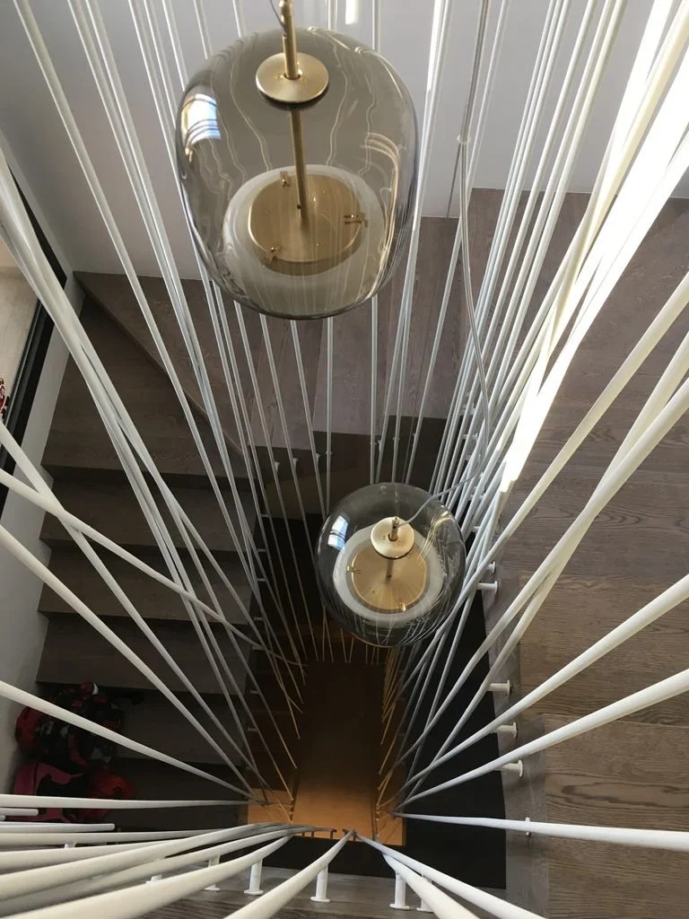 Lámparas colgantes de vidrio y metal en una escalera en el interior