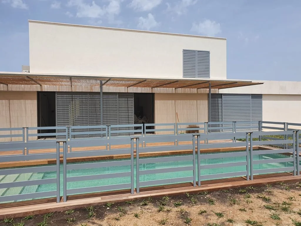Casa moderna con piscina y terraza, vista frontal.