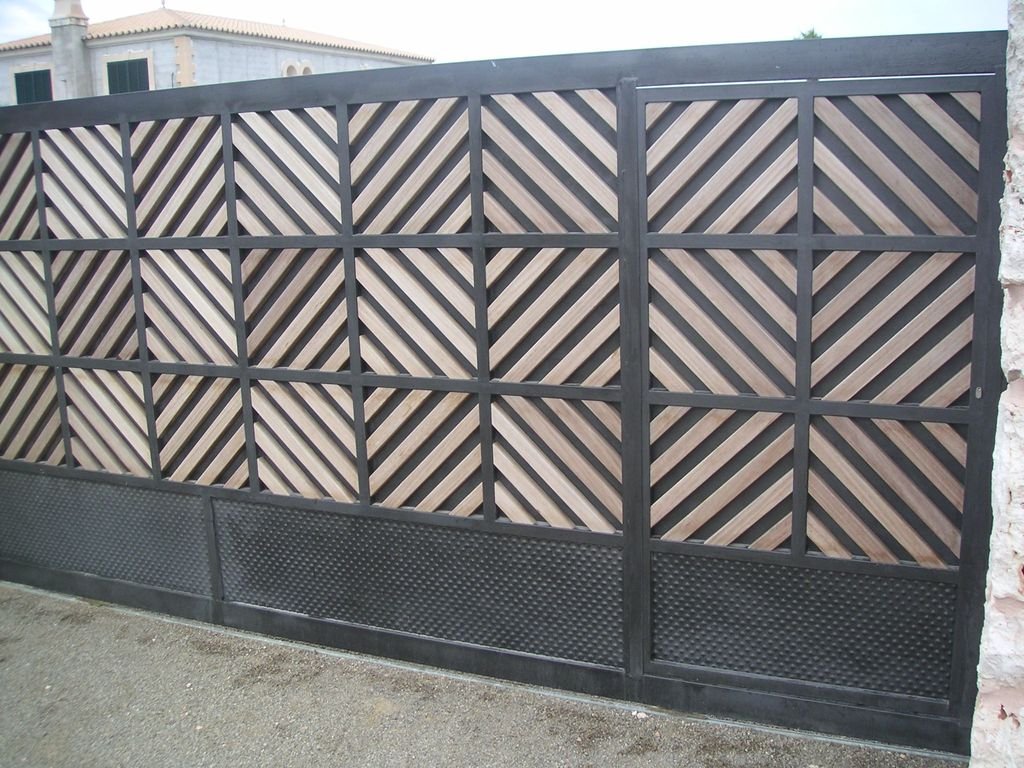 Puerta de metal con diseño de listones diagonales en forma de rombos y sección inferior de patrón de puntos.