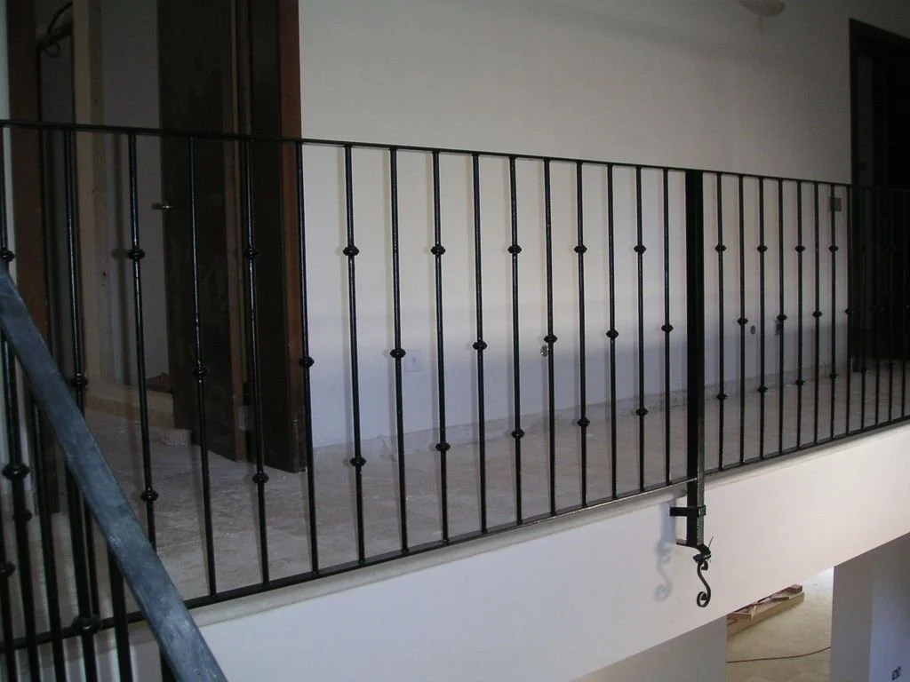 Barandal de metal negro en una terraza o balcón de una casa.
