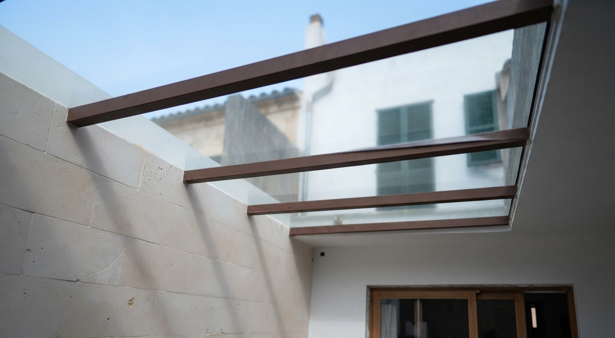 Techo con estructura de madera y vidrio, vista hacia el cielo y edificios cercanos.