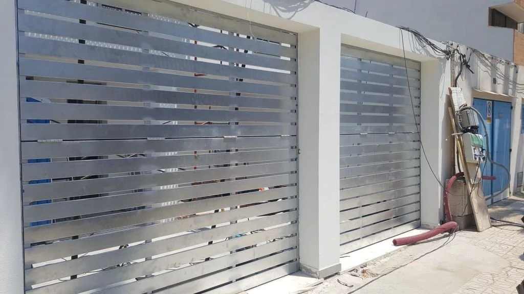 Escaparatadas metálicas en un edificio con estructura moderna, con cables y herramientas apoyadas en la pared.