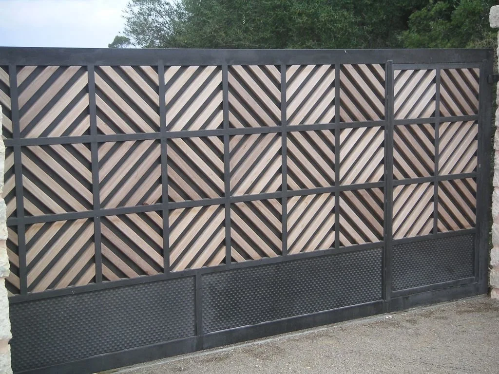 Puerta de garaje de metal con diseño de listones de madera en forma de triángulo, con parte inferior de malla de metal