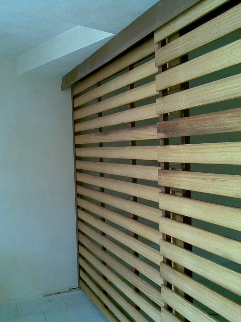 Pared decorativa de listones de madera en un interior, con un diseño horizontal y espacio entre cada listón.