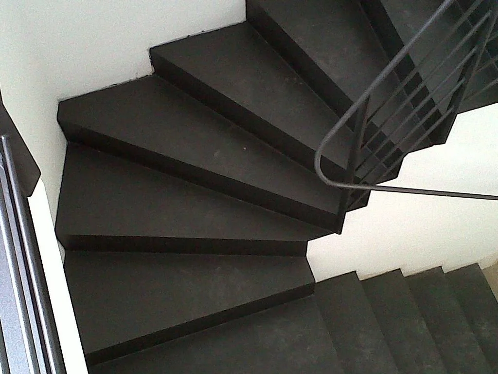 Escalera de color negro en un edificio, vista desde arriba hacia abajo.