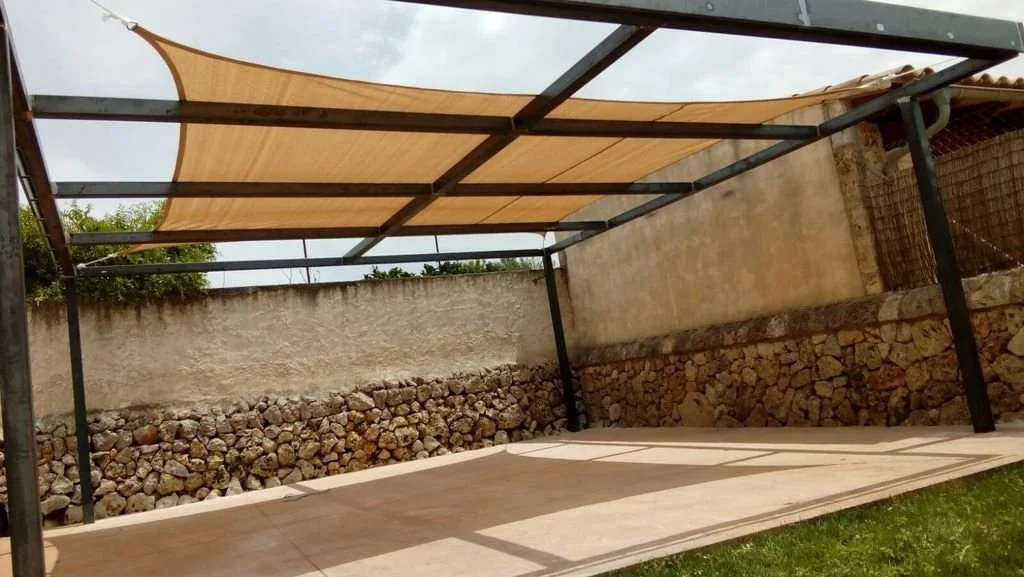Estructura de concreto con techo de tela en un espacio exterior