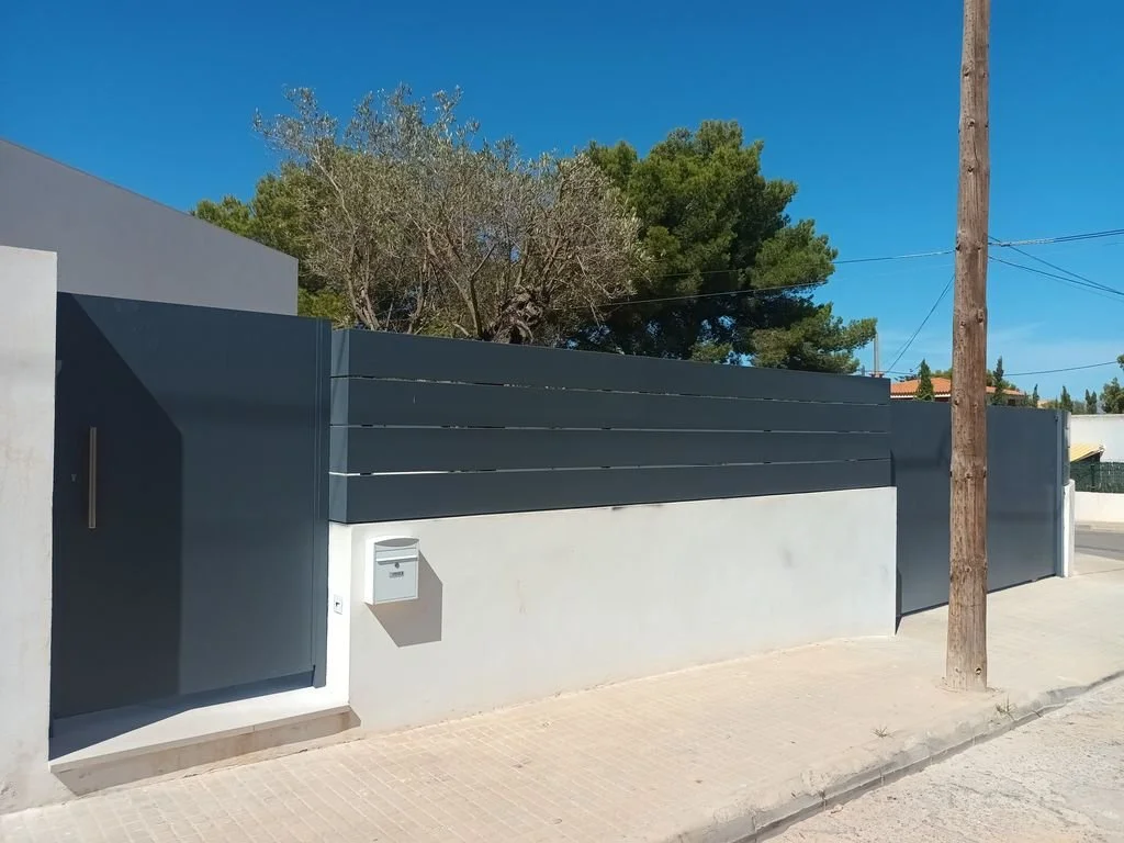 Muros y puerta de entrada de apaga y vámonos en color gris oscuro en un ambiente residencial