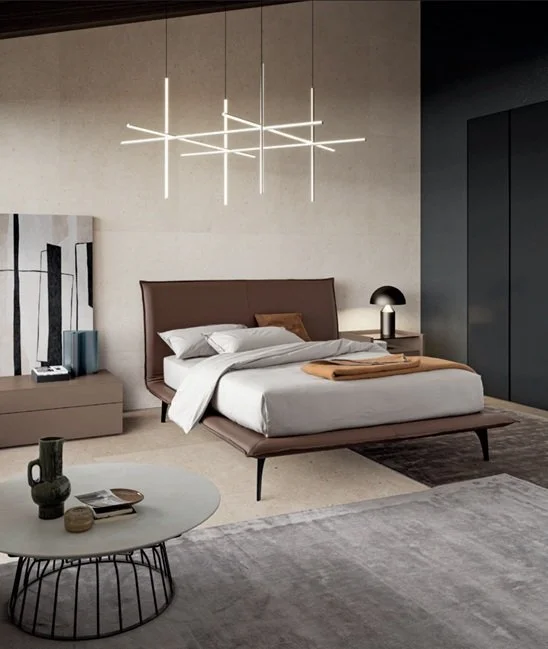 Camera moderna con letto, lampada da notte, decoro minimalista e soffitto con lampadario lineare LED.