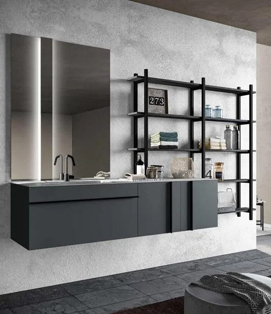 Angolo di cucina moderna con pensili e scaffali neri, lavabo con rubinetto nero, parete e pavimento scuri, e alcuni oggetti decorativi e tessuti sugli scaffali.