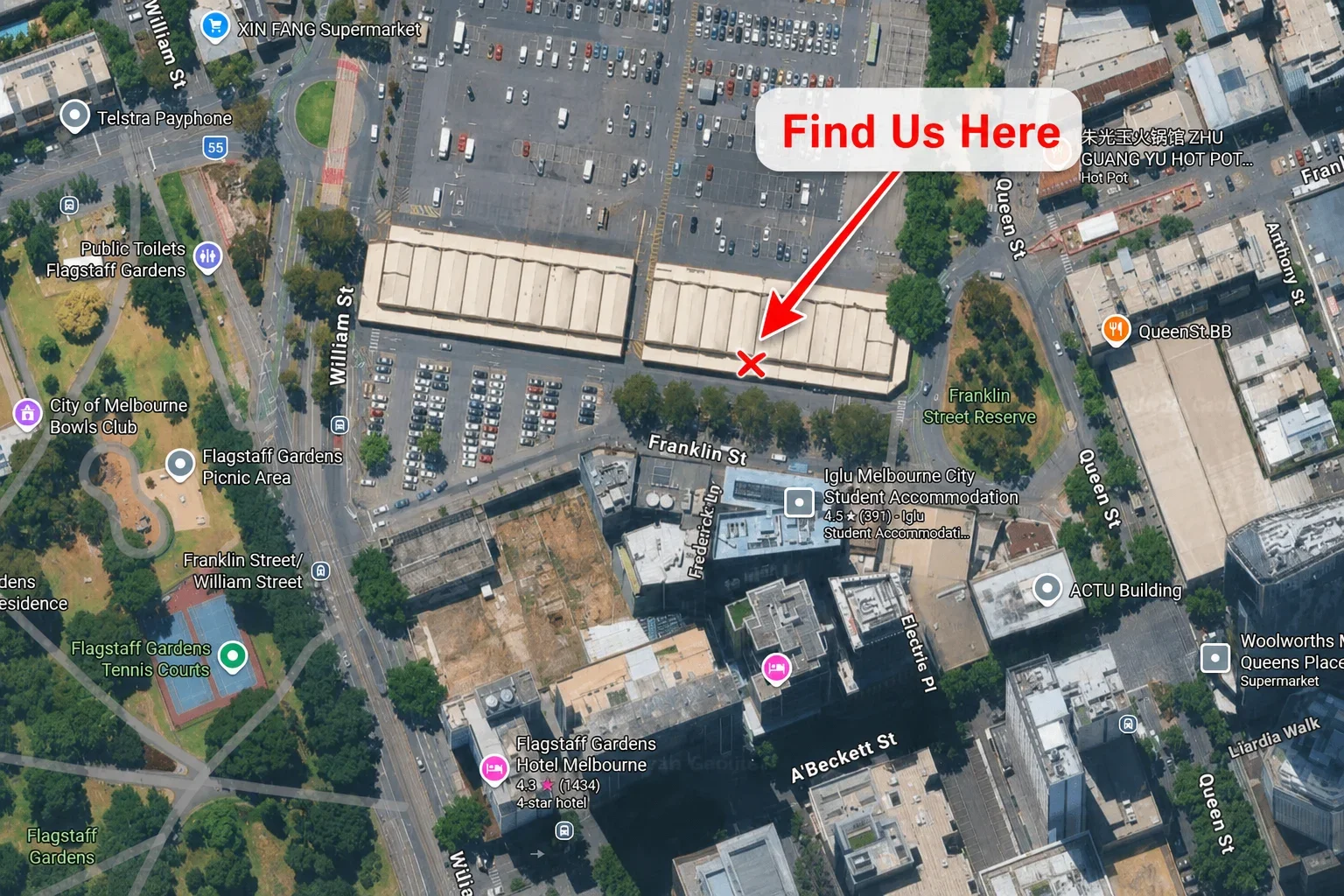 Aerial view of Melbourne city with a highlighted building and a red arrow pointing to it labeled 'Find Us Here.' Surrounding streets, parking lots, and nearby landmarks such as Franklin Street Reserve, a supermarket, and a hotel are visible.