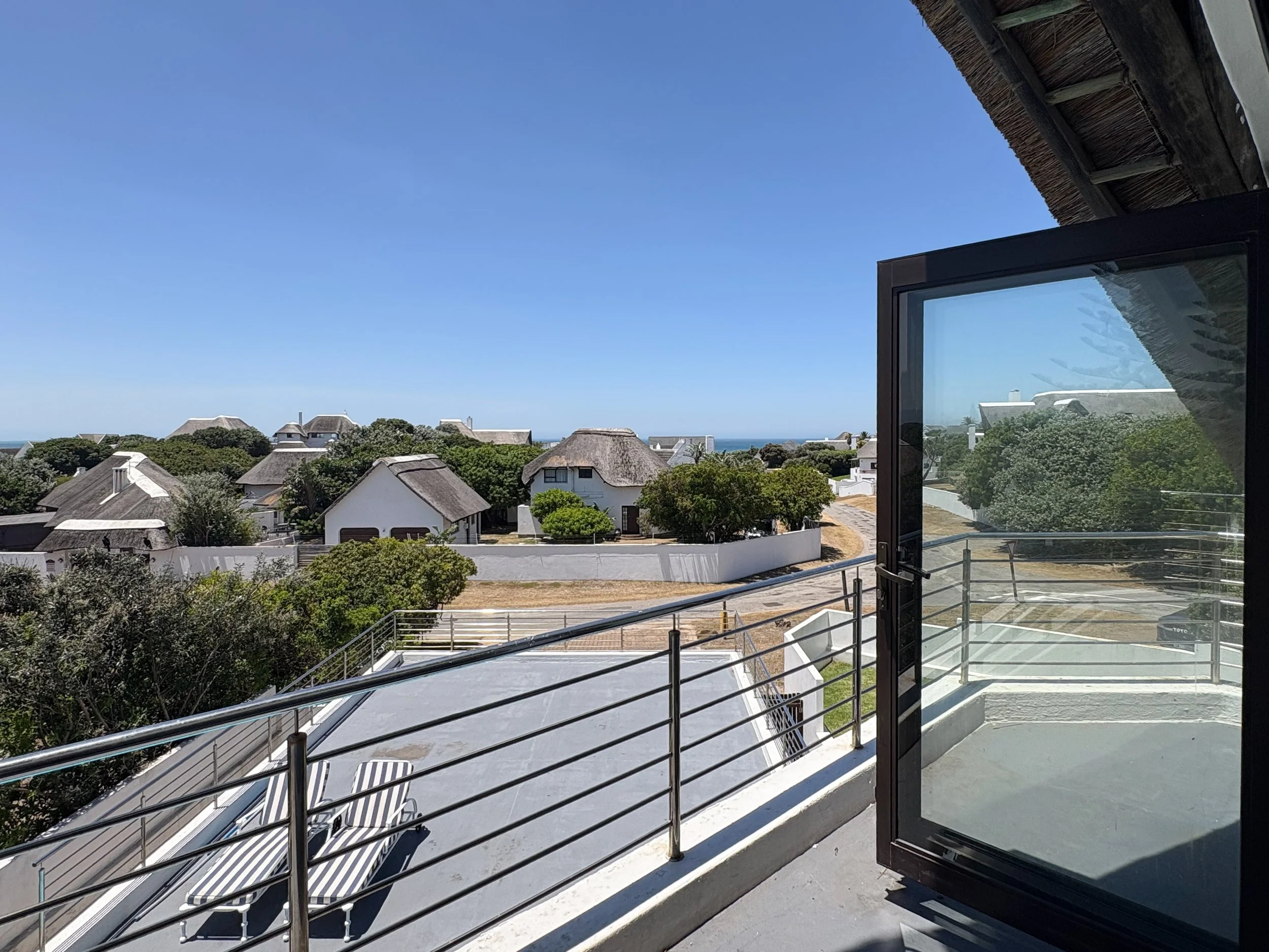 Sea-facing balcony view over St Francis Bay rooftops from the upstairs bedroom