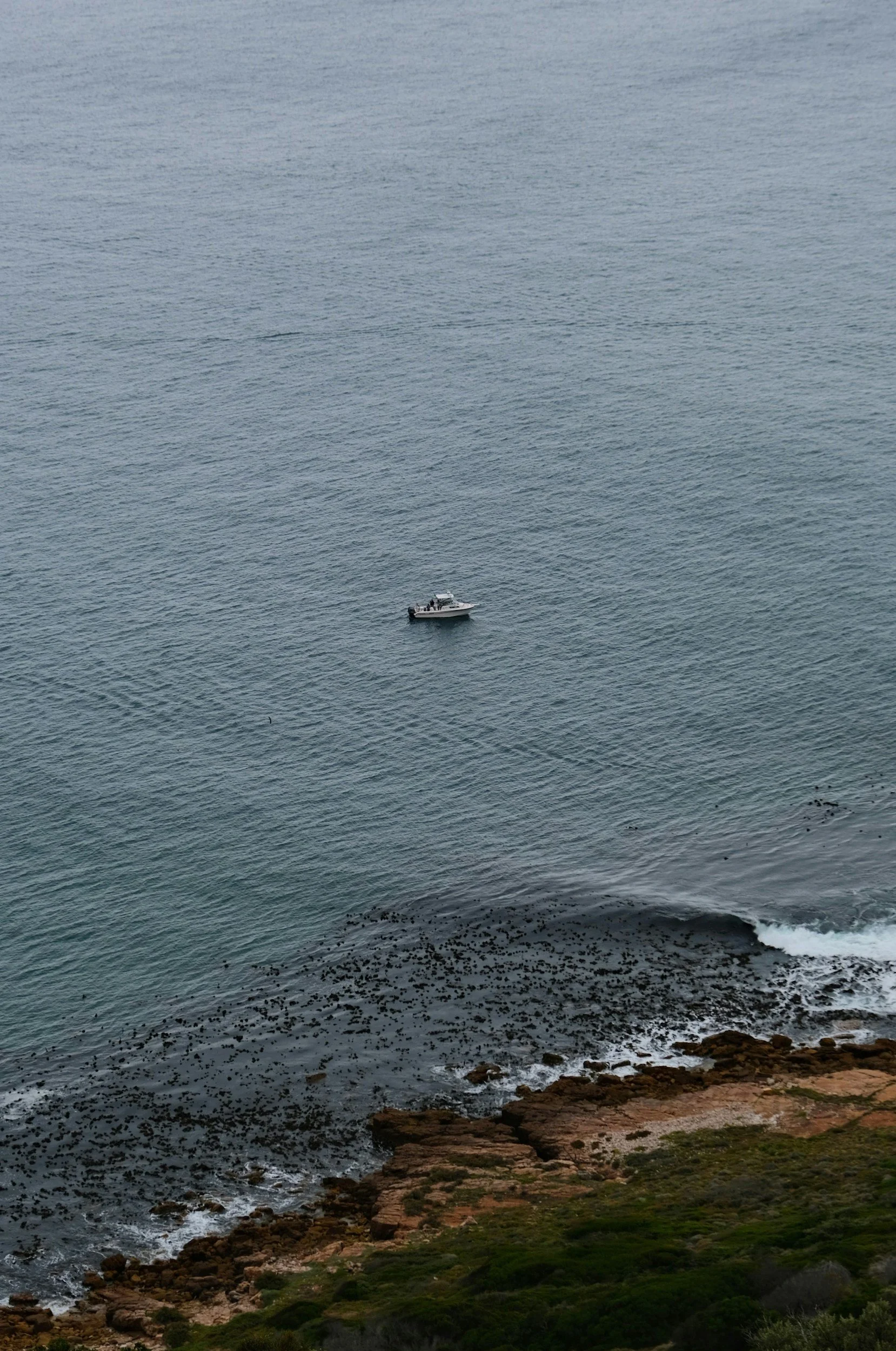 Fishing boat off the rocky coastline near St Francis Bay harbour