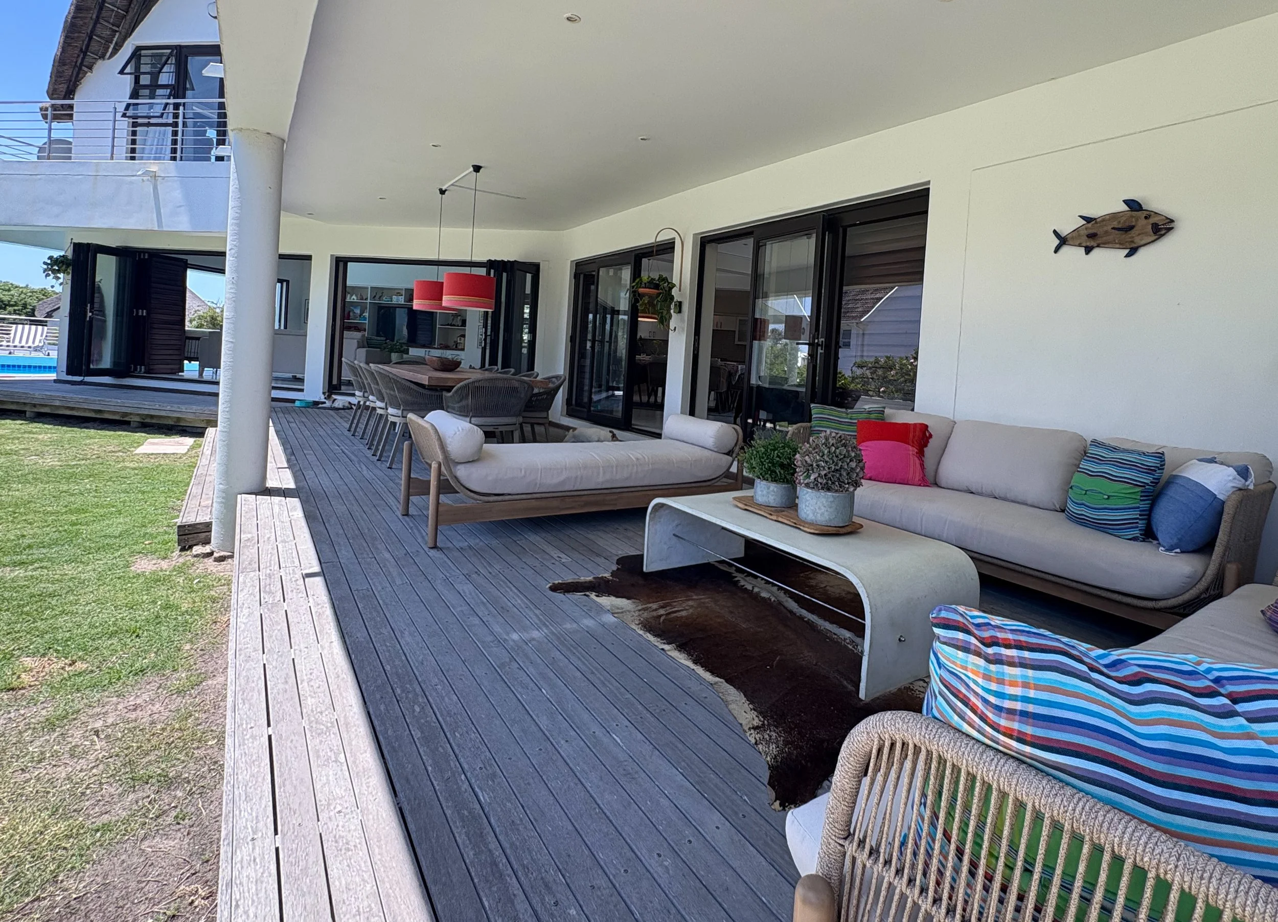 Patio lounge and dining table view down the length of the covered deck