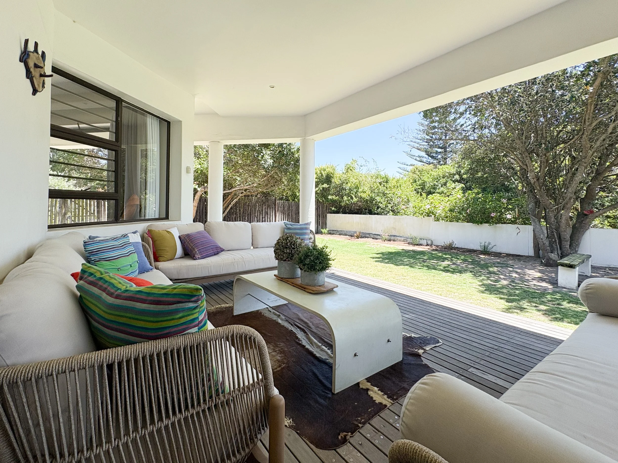 	Patio lounge seating with garden view through the fence line