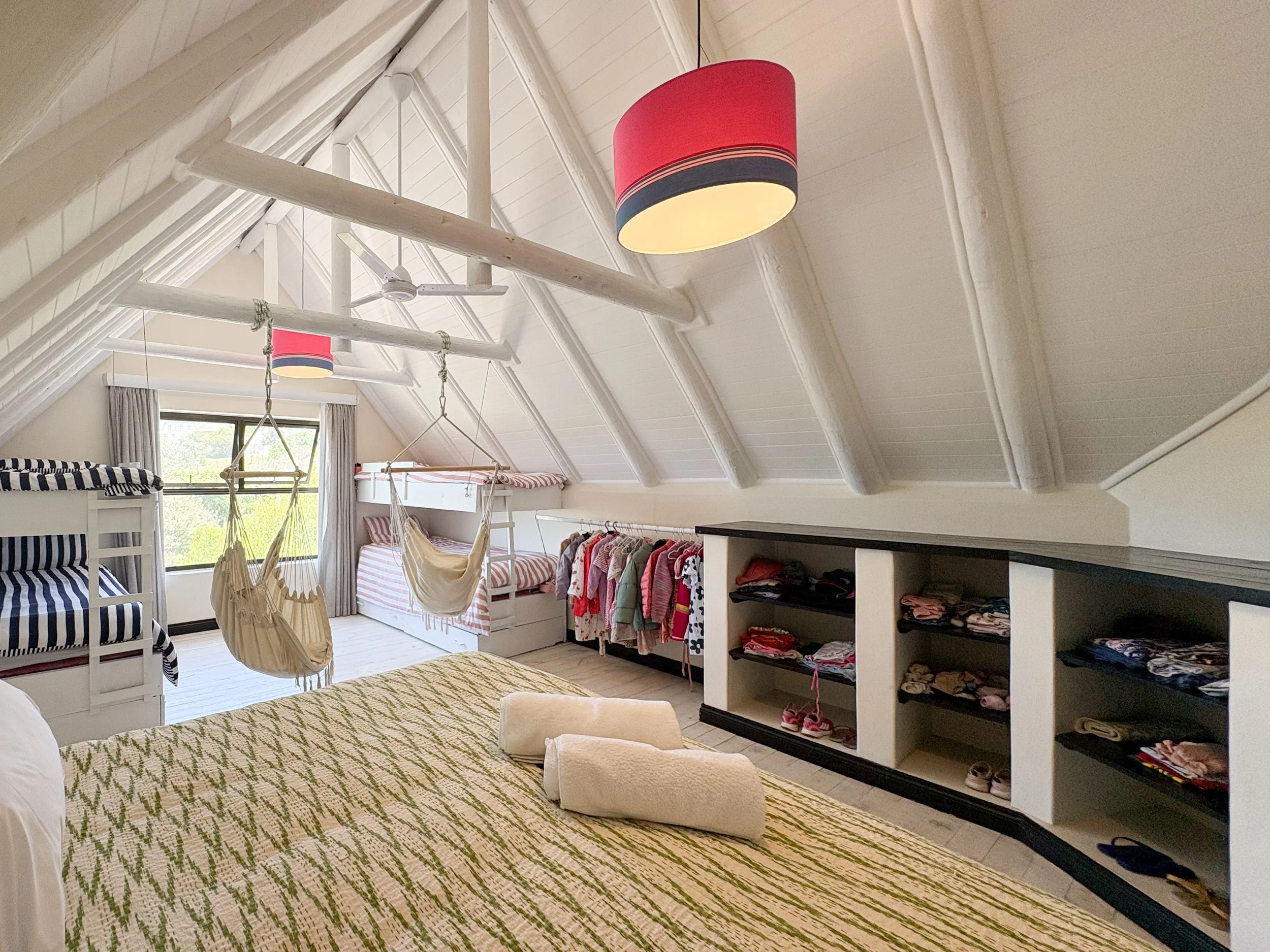 Dorm bedroom with hammock chairs and open wardrobe storage
