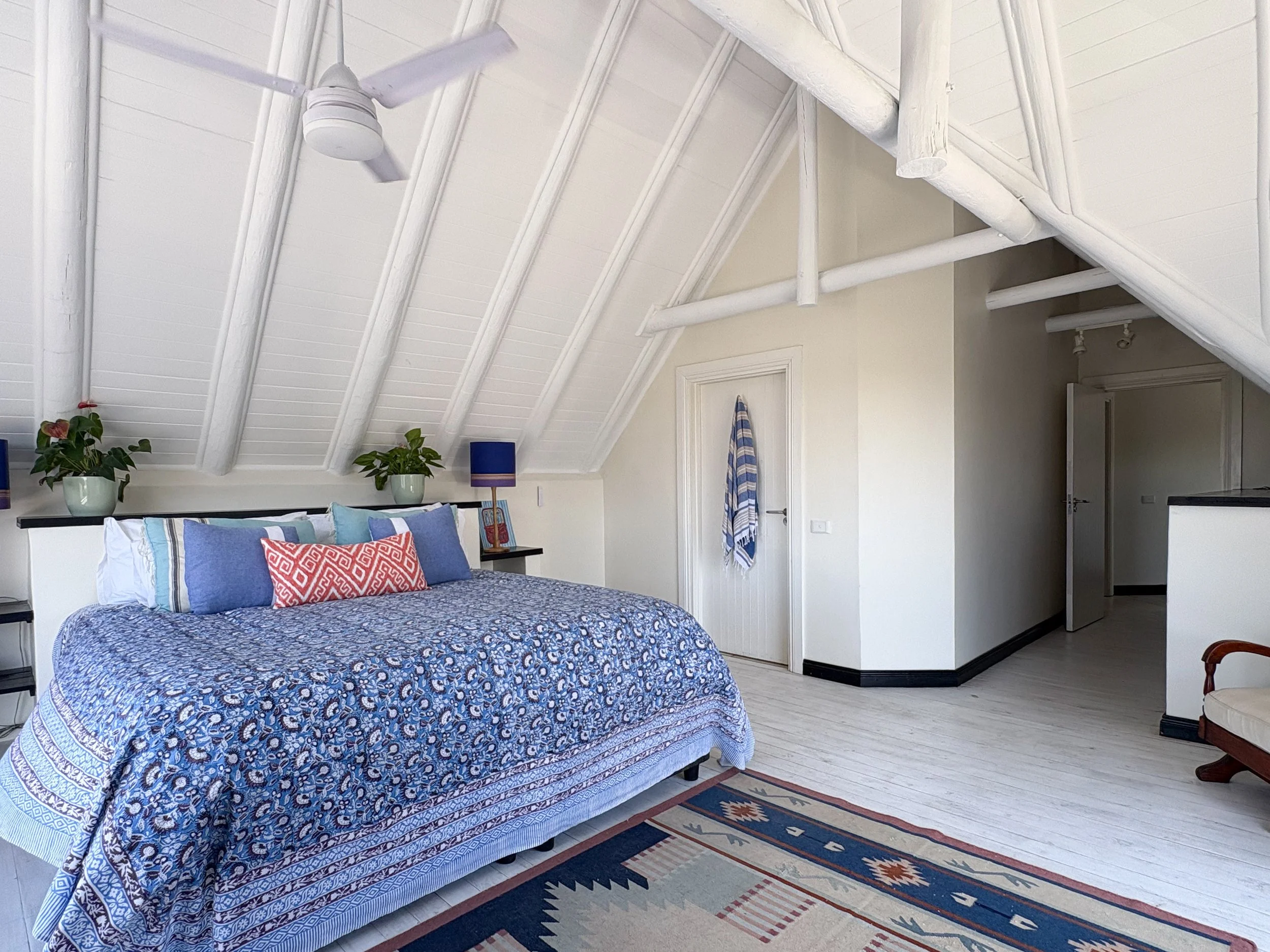 King bed with blue patterned throw and open-plan landing beyond