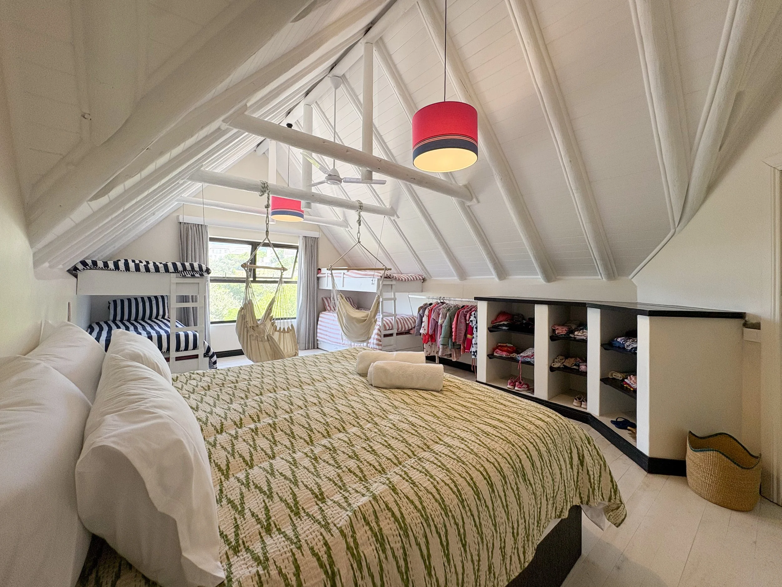 Dorm bedroom with king bed, bunk beds and hanging hammock chairs