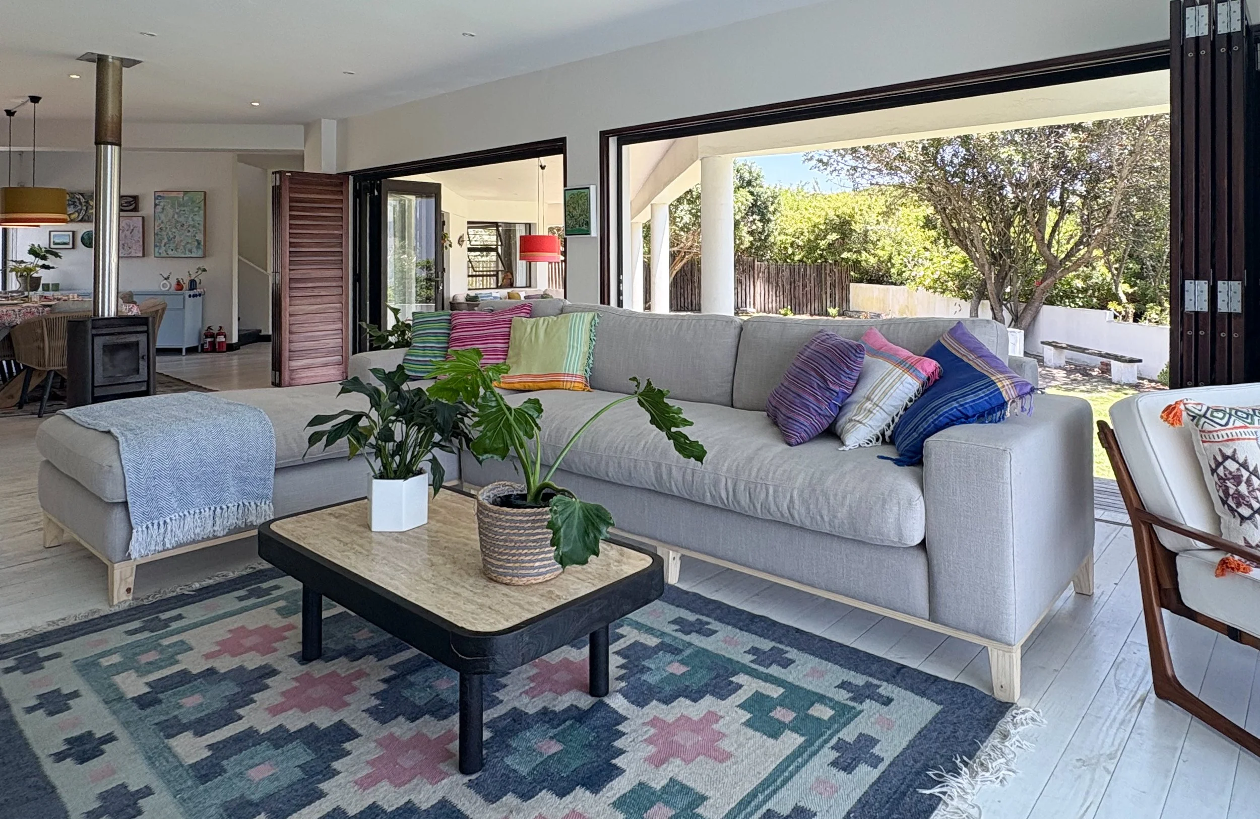 Lounge with log burner and sofa opening onto the covered patio