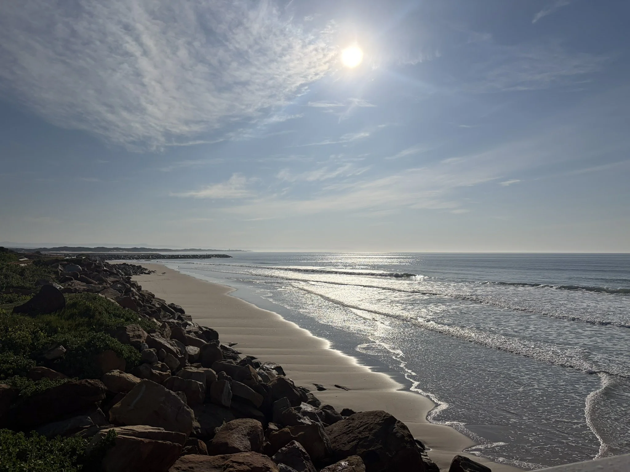 sunlit coastline with waves actually breaking