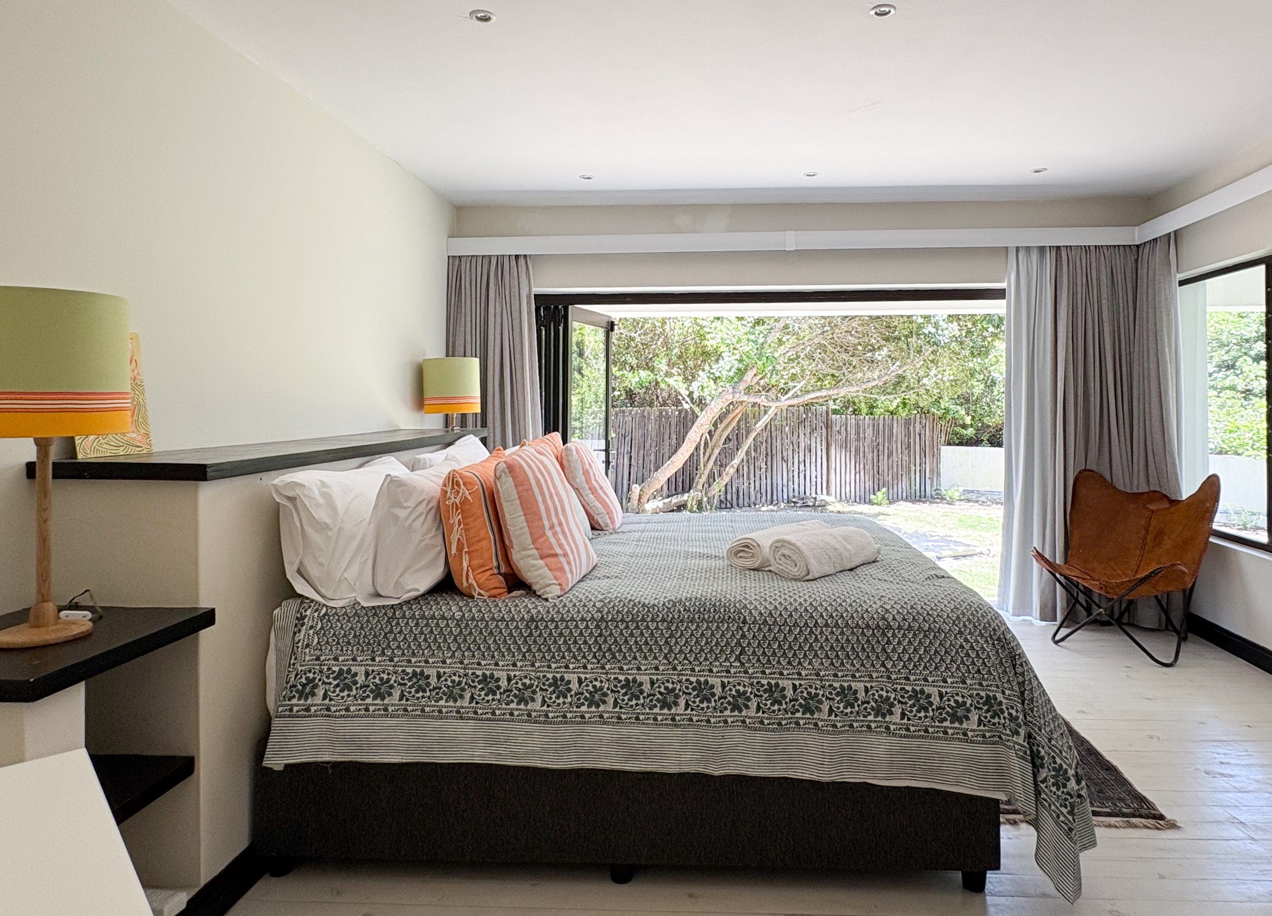 King bed with leather butterfly chair and garden view