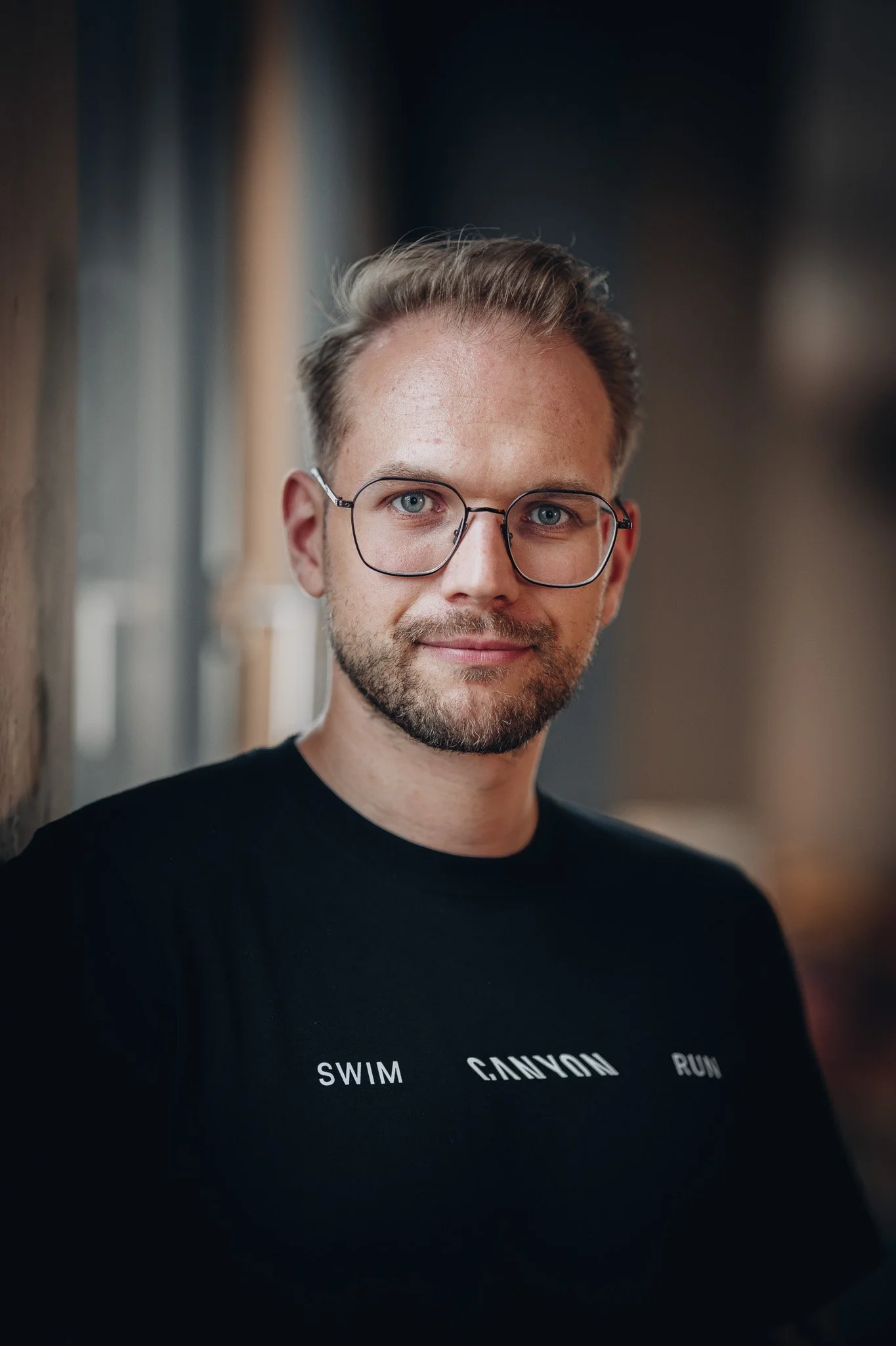 Portrait eines Mannes mit Brille im schwarzen Shirt – Business-Portrait Koblenz