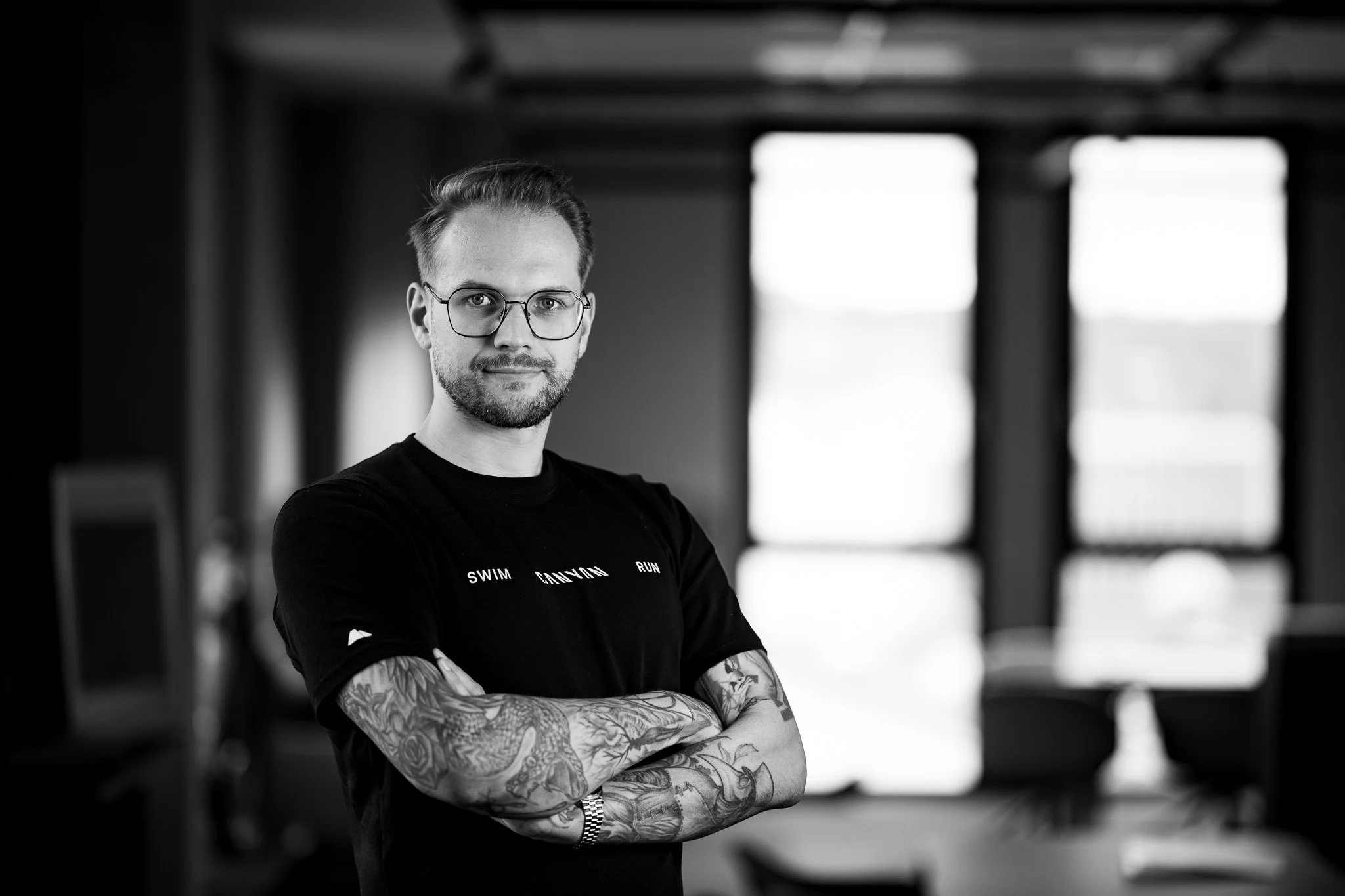 Schwarz-Weiß-Portrait eines Unternehmers mit verschränkten Armen – Business-Fotografie