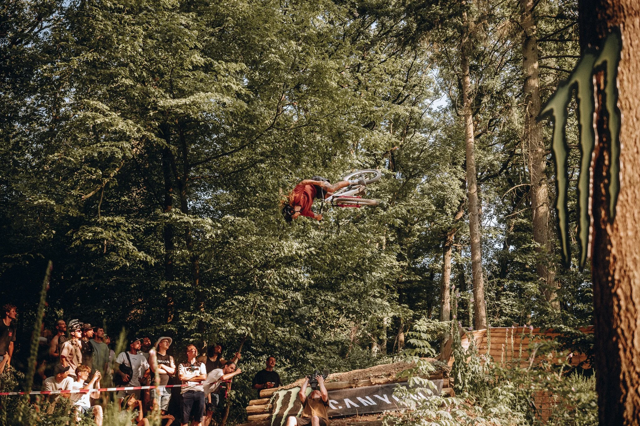 Motorradfahrer in einem Wald bei einer Stunt-Show, Zuschauer im Hintergrund. Marvin Lahrs Sport Mountainbike Event Fotograf