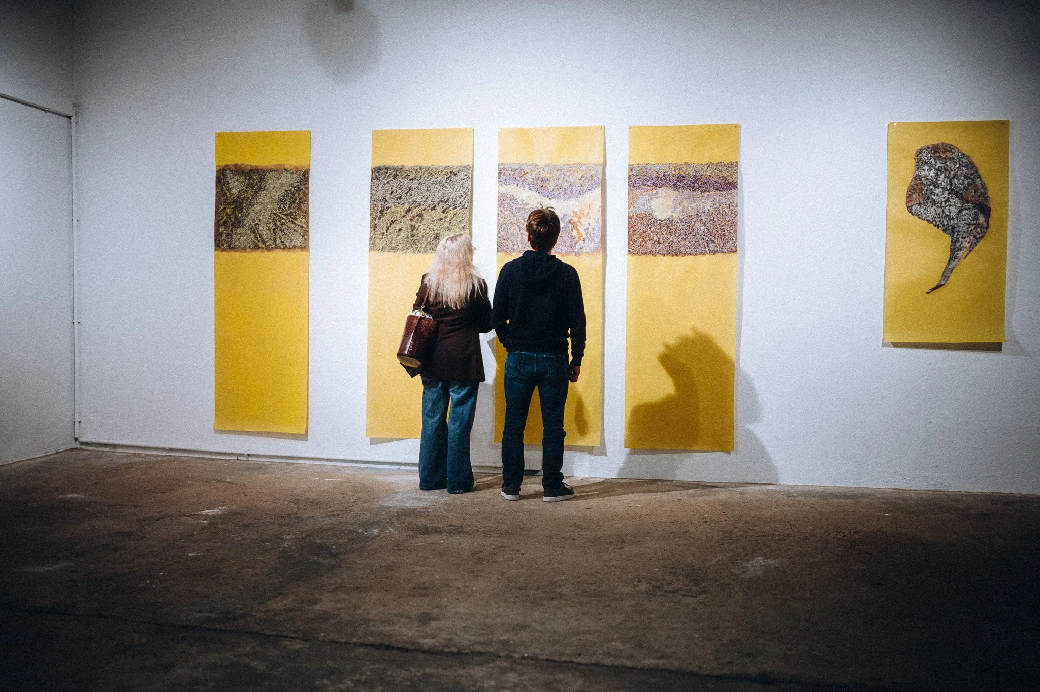 Paar vor großformatigen gelben Kunstwerken in einer Galerie – Eventfotografie Koblenz