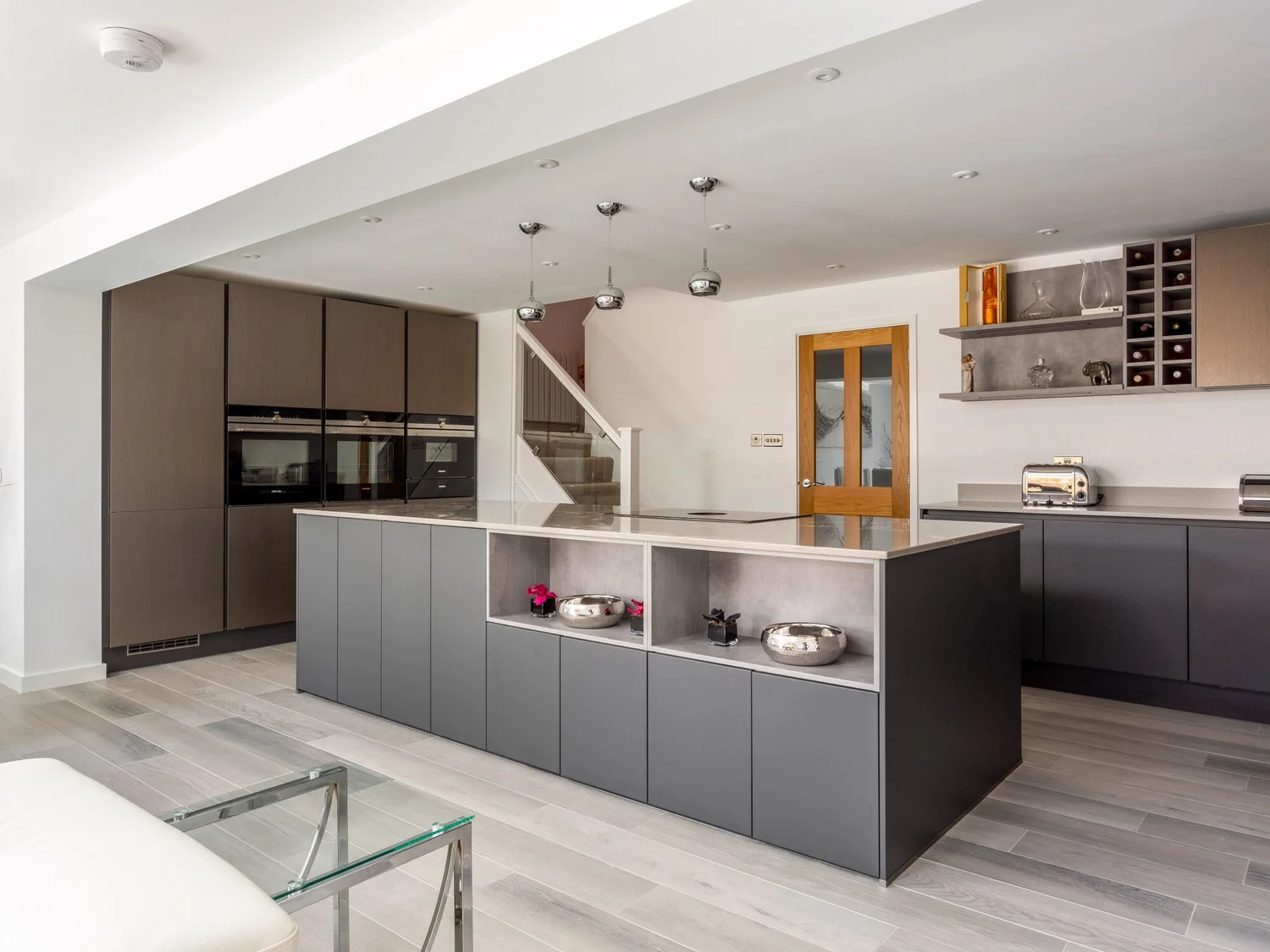 Modern fitted kitchen with dark cabinetry and stone worktops