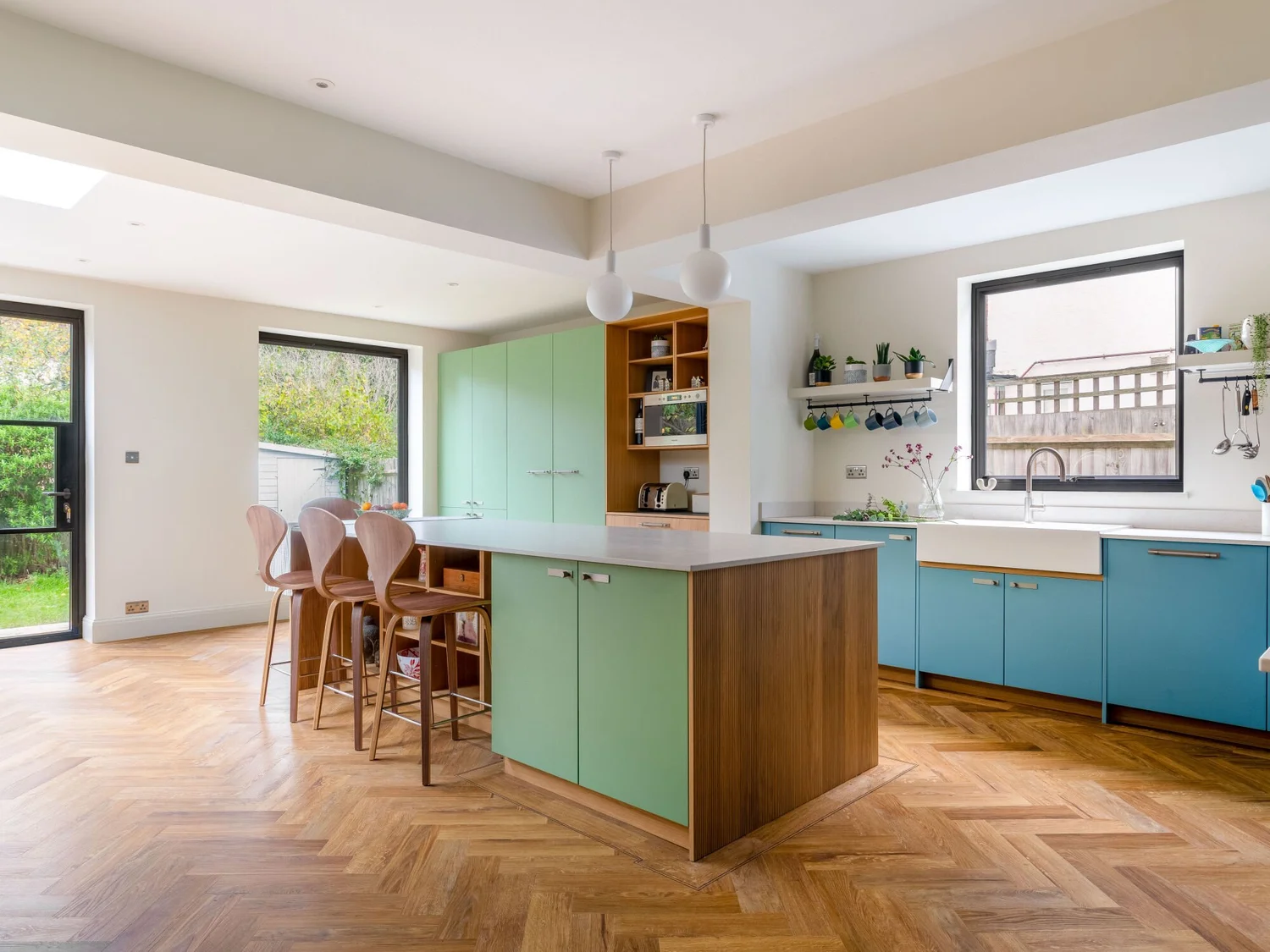 Green and timber kitchen renovation with island and parquet flooring