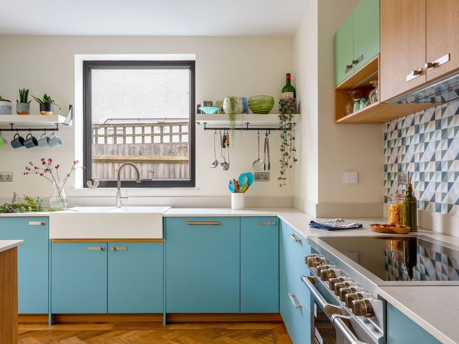 Blue fitted kitchen with tiled splashback and timber worktops