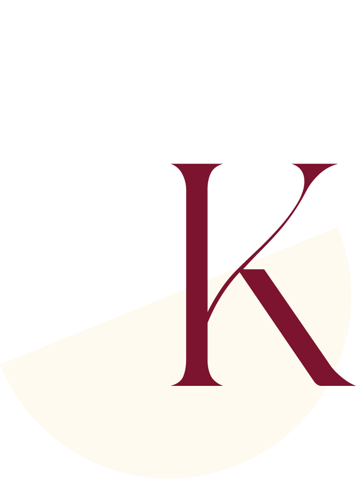 A black background with a large cream-colored semicircle at the bottom. Overlapping the semicircle is a large, dark burgundy letter 'K' and a smaller '2' in the same color.