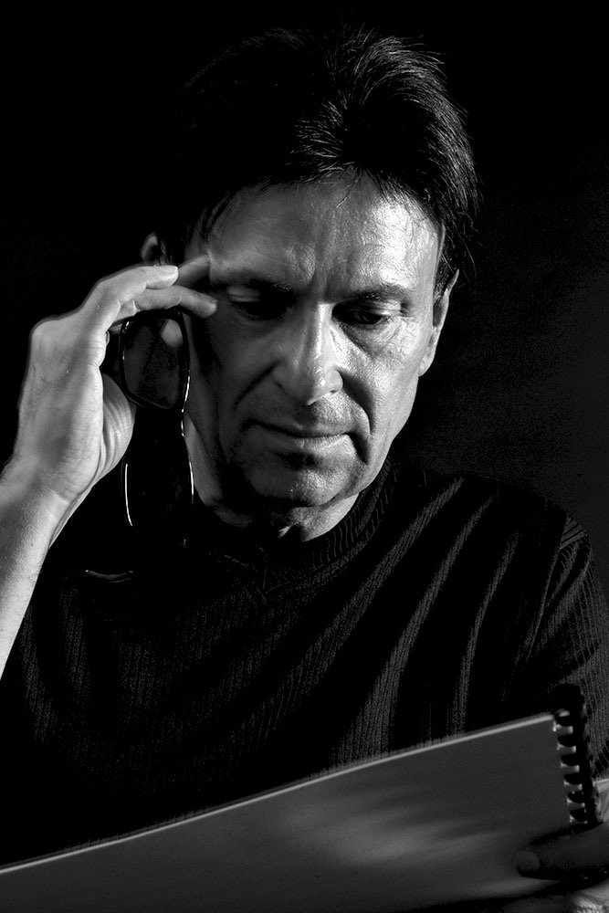 Black and white photo of Rolf Becker, studying one of his scores.