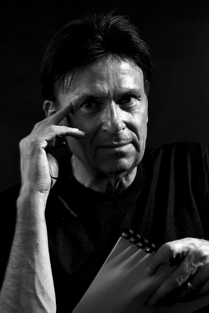 Black and white photo of Rolf Becker, holding one of his scores.
