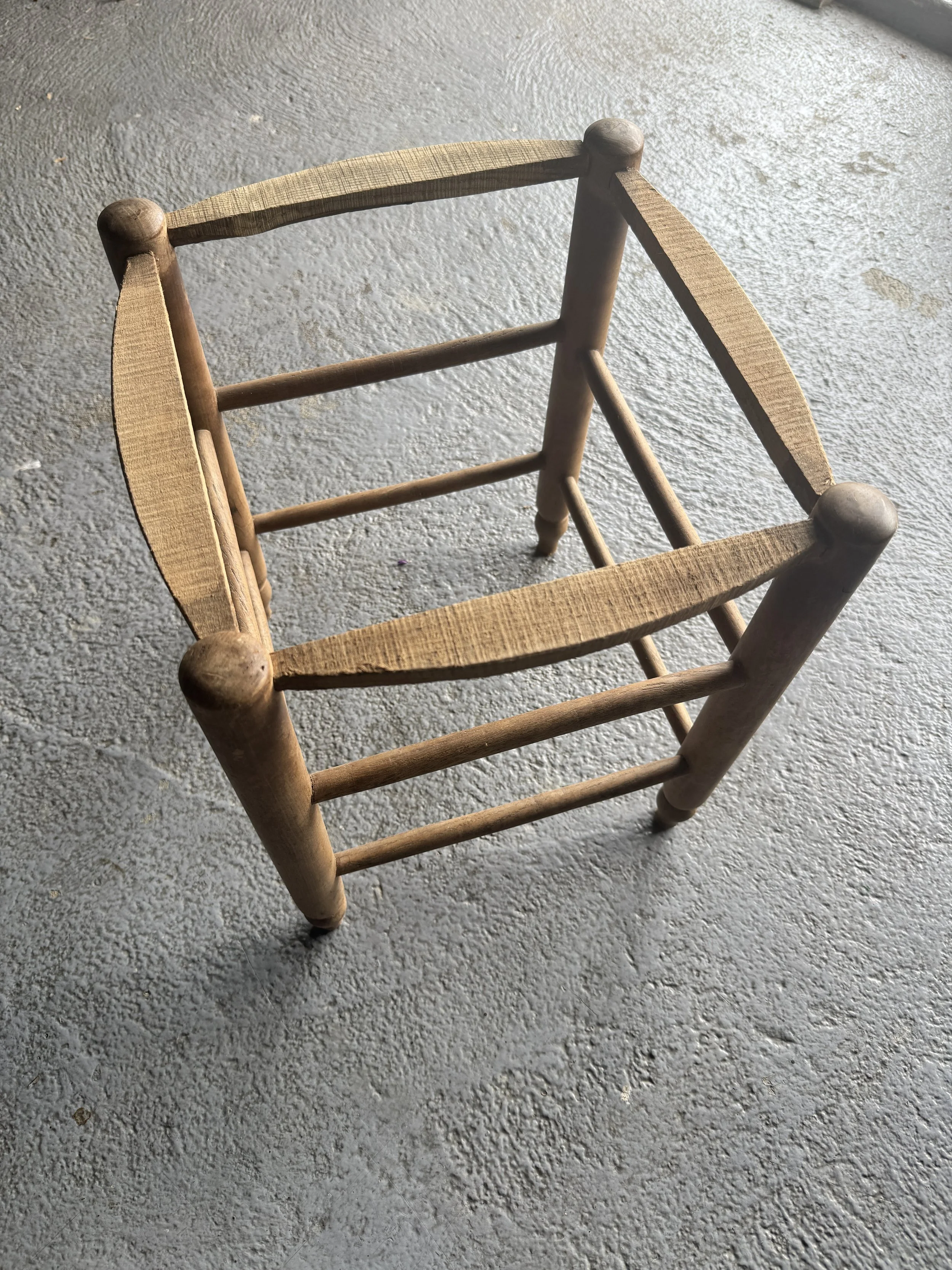 Chaise en bois vue de dessus sur un sol en béton.