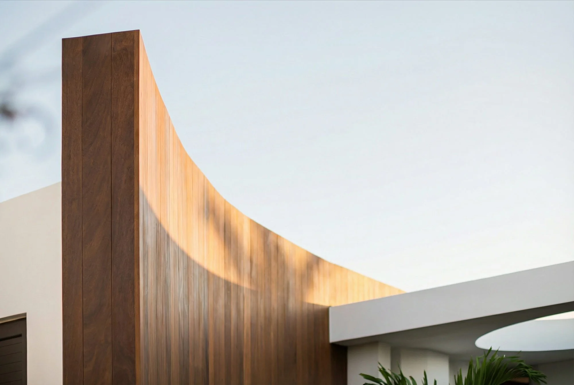 Bois de Chandelles villa — curved timber facade and white architectural volumes.