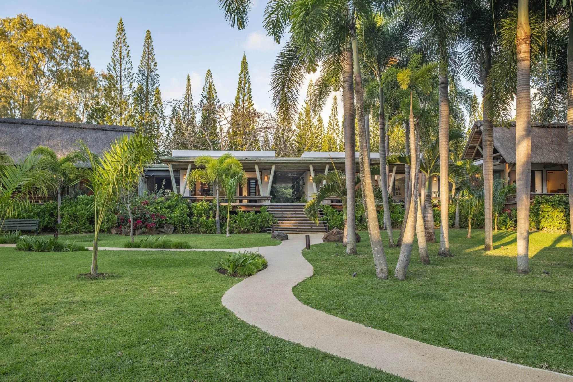 Muse Villa — tropical garden and architecture connected by a curved path.