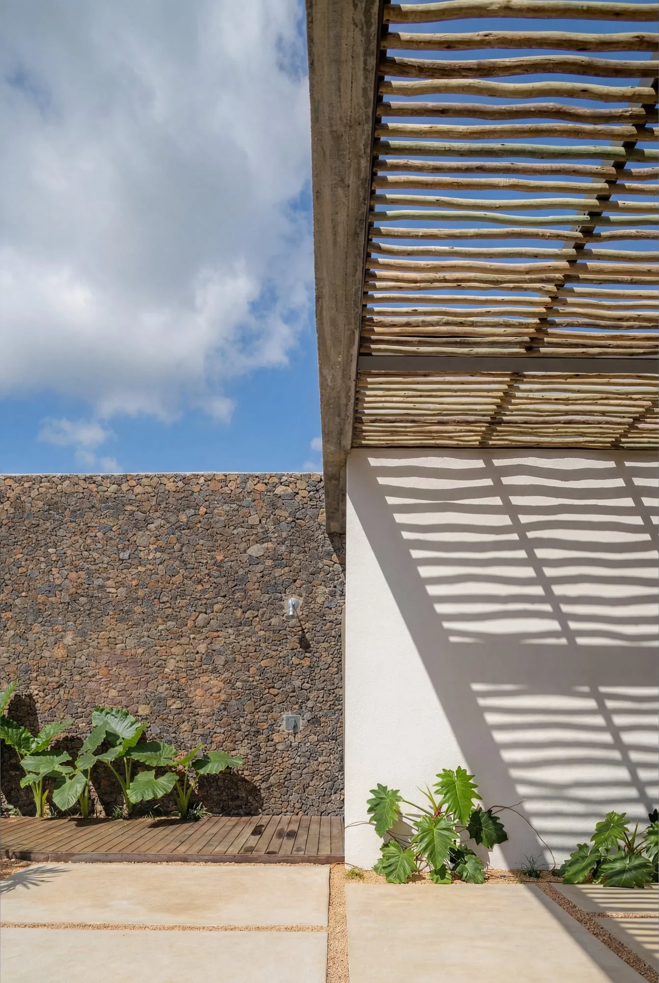 Villa Anahita H15 — slatted pergola casting shadows on a white wall.