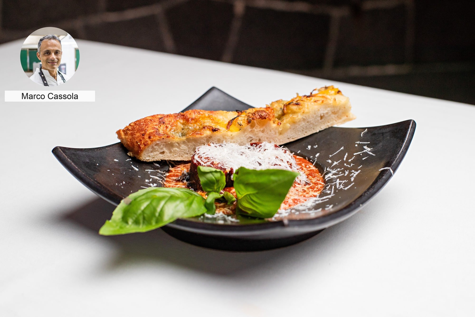 Toasted bread with basil garnish by chef Marco Cassola.