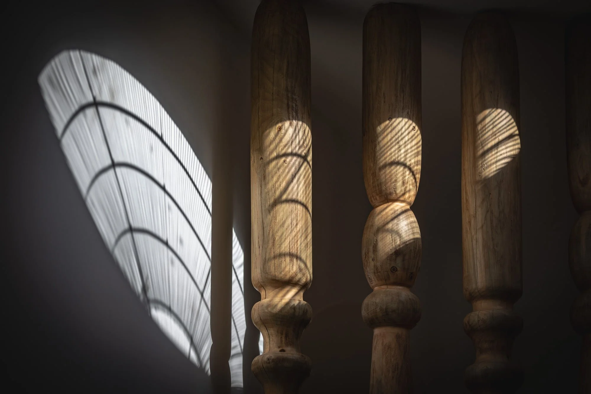 Muse Villa — light and shadow from a circular skylight and timber columns.