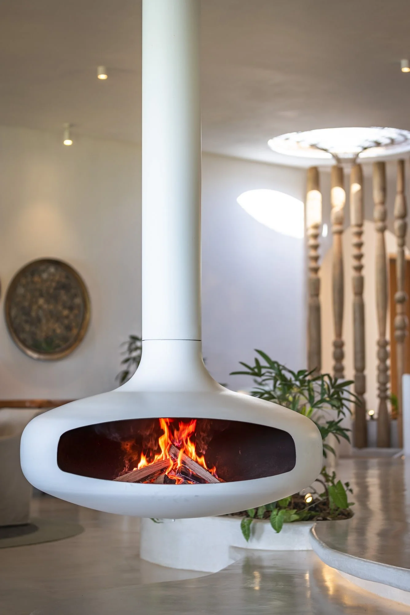 Muse Villa — sculptural white fireplace and circular skylight.