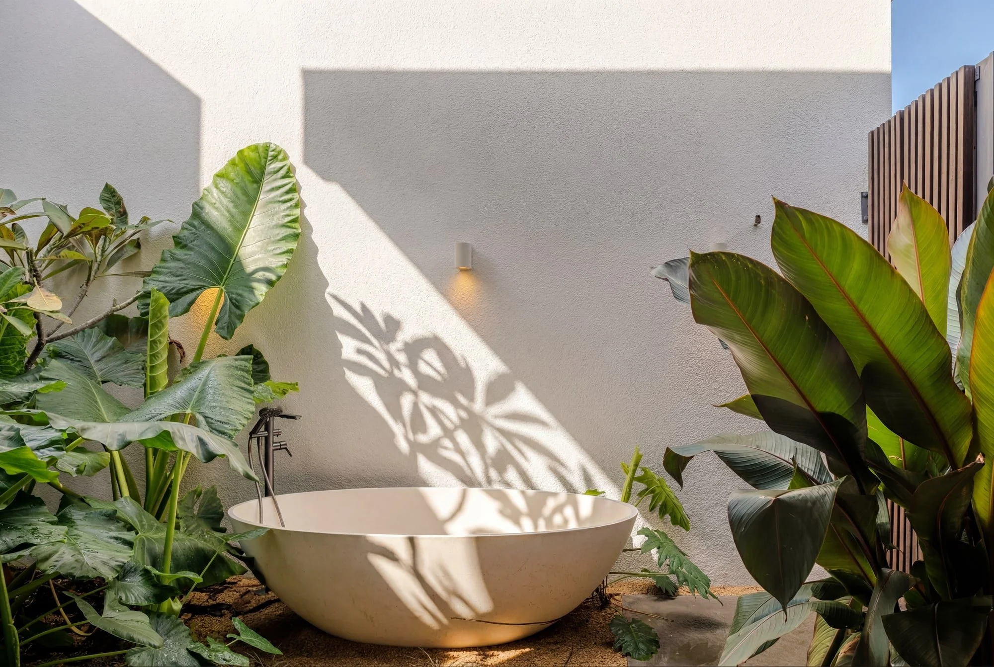 Villa Anahita H15 — freestanding bathtub in a minimalist outdoor courtyard.
