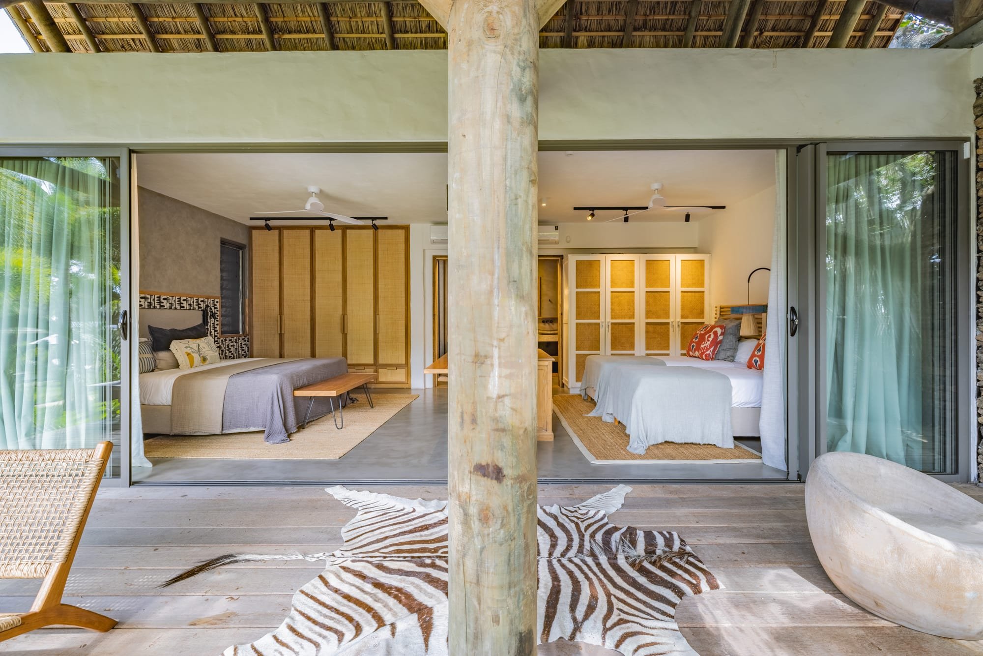 Muse Villa — bedroom opening onto a timber terrace and tropical garden.
