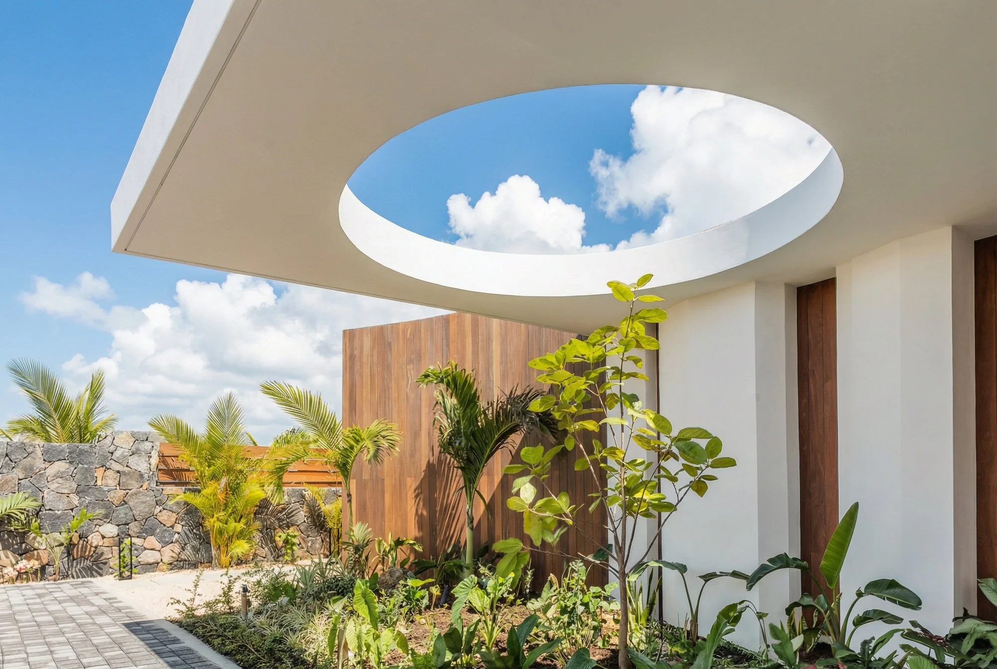Bois de Chandelles villa — circular roof opening framing the sky.