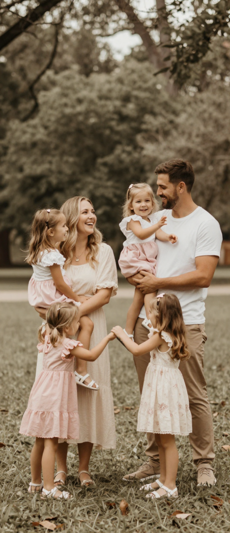 Famiglia sorridente e felice che si abbraccia al perco