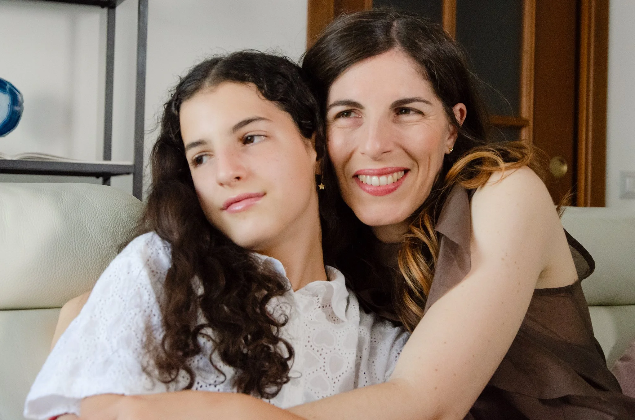 Madre e figlia abbracciate che sorridono felici