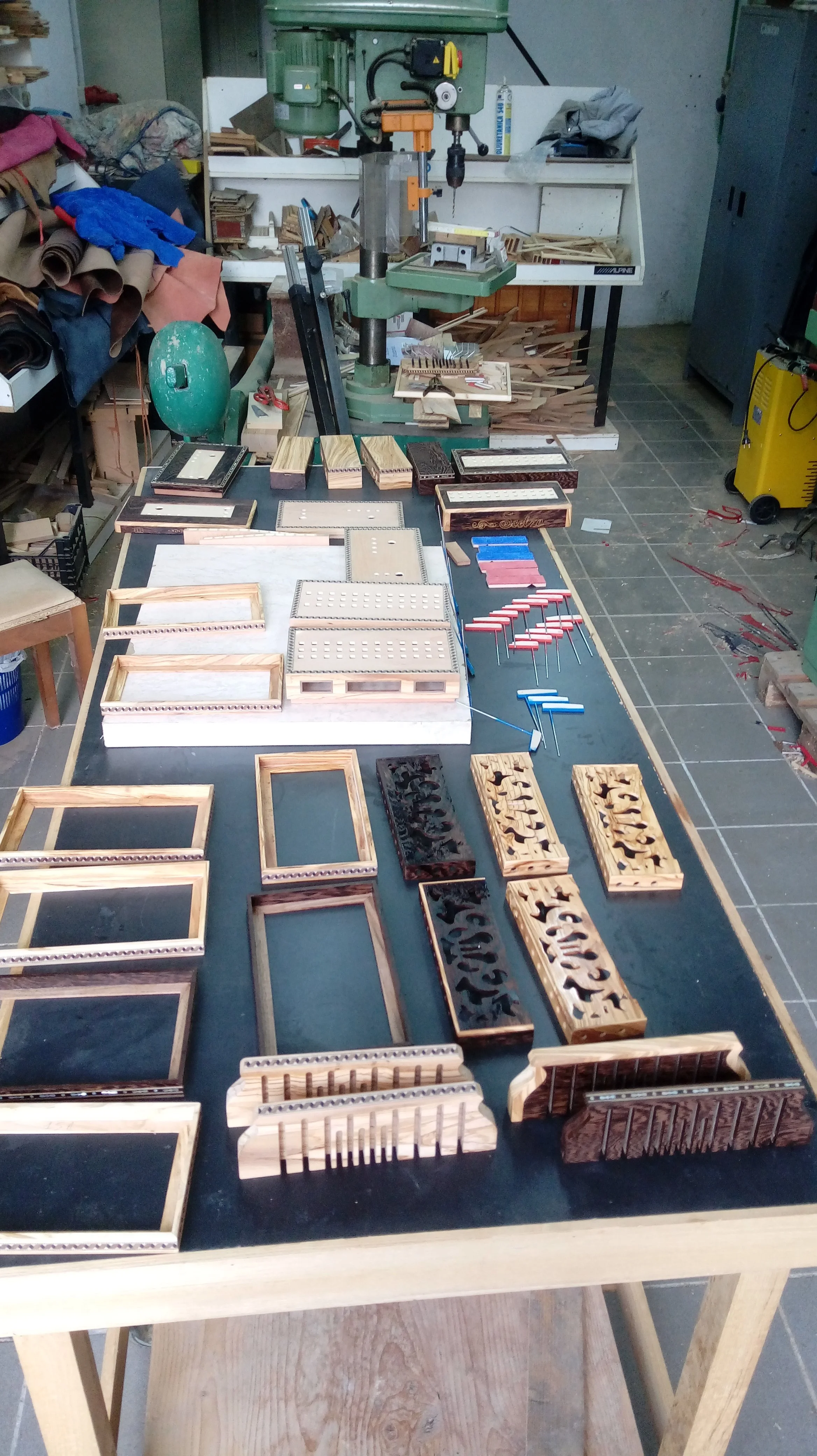 Lavoro artigianale su cornici e piccoli oggetti in legno in un laboratorio.