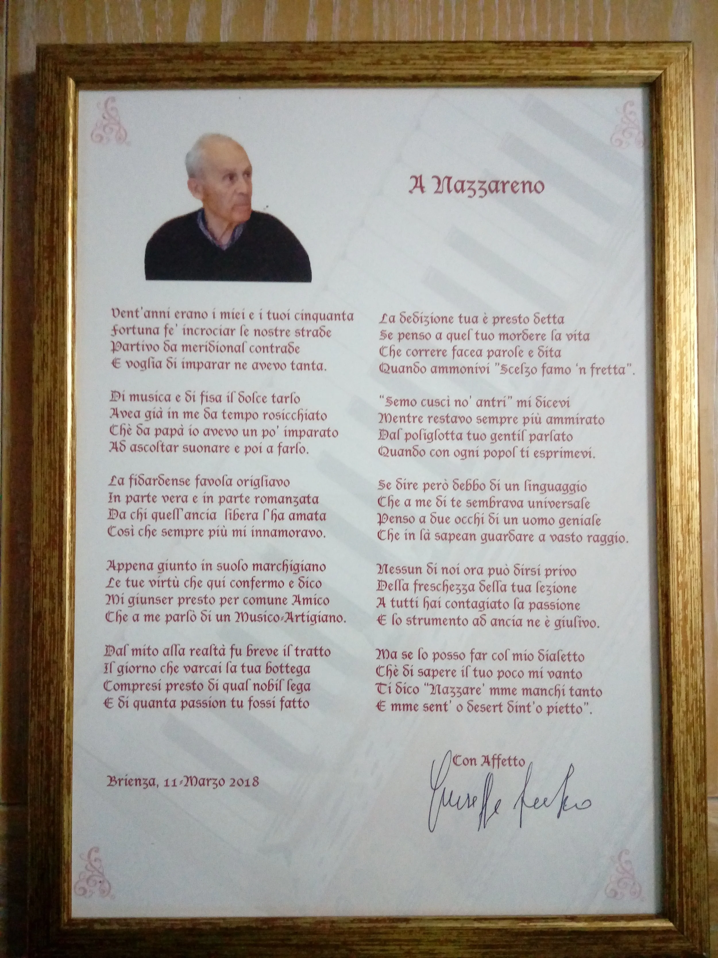 Una poesia dedicata a Nazzareno scritta su un foglio, con una foto di un uomo anziano sulla sinistra e una firma a piè di pagina, il tutto incorniciato in un telaio di legno.