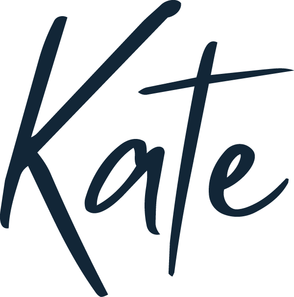 Stylized handwritten text that reads 'Kate' in dark blue on a black background.