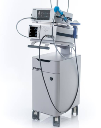 Medical ventilator machine with control panel, connected tubes, and a robotic arm, on a wheeled cart.